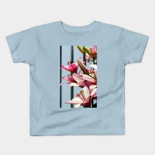 Fresh pink lilies at the fence background Kids T-Shirt